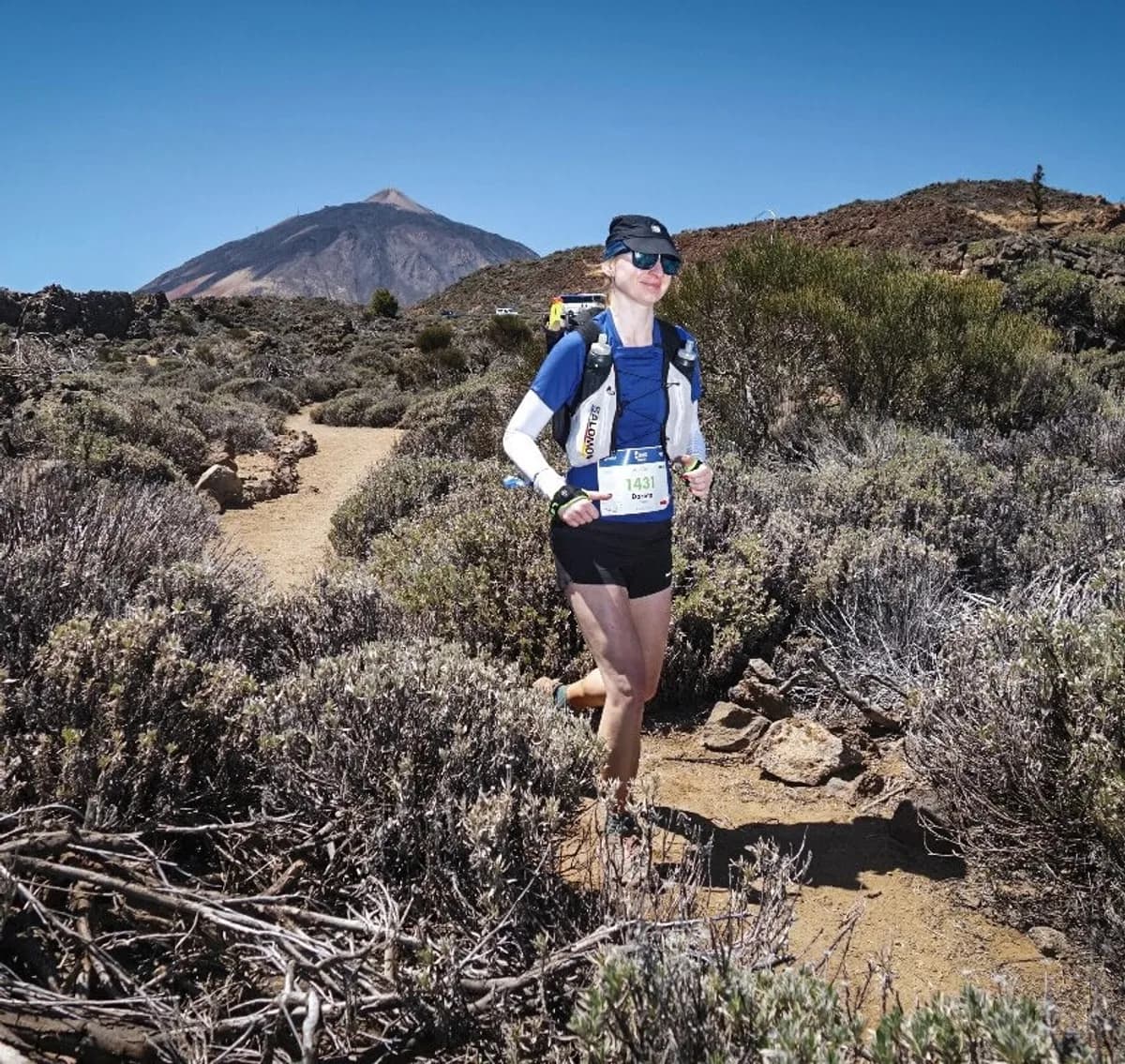 Trail runner on a scrubland path with Mount Teide behind